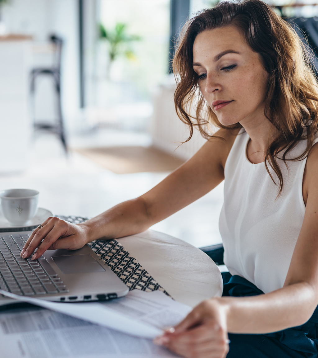 Mujer revisando su nómina en portátil antes de solicitar un préstamo con ASNEF en España